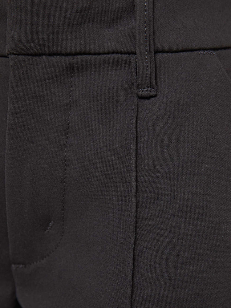 Swatch view of a woman in a high-rise bootcut trouser with a zip fly, looser leg, pintuck details down the front, a long 34-inch inseam and a slit hem. 