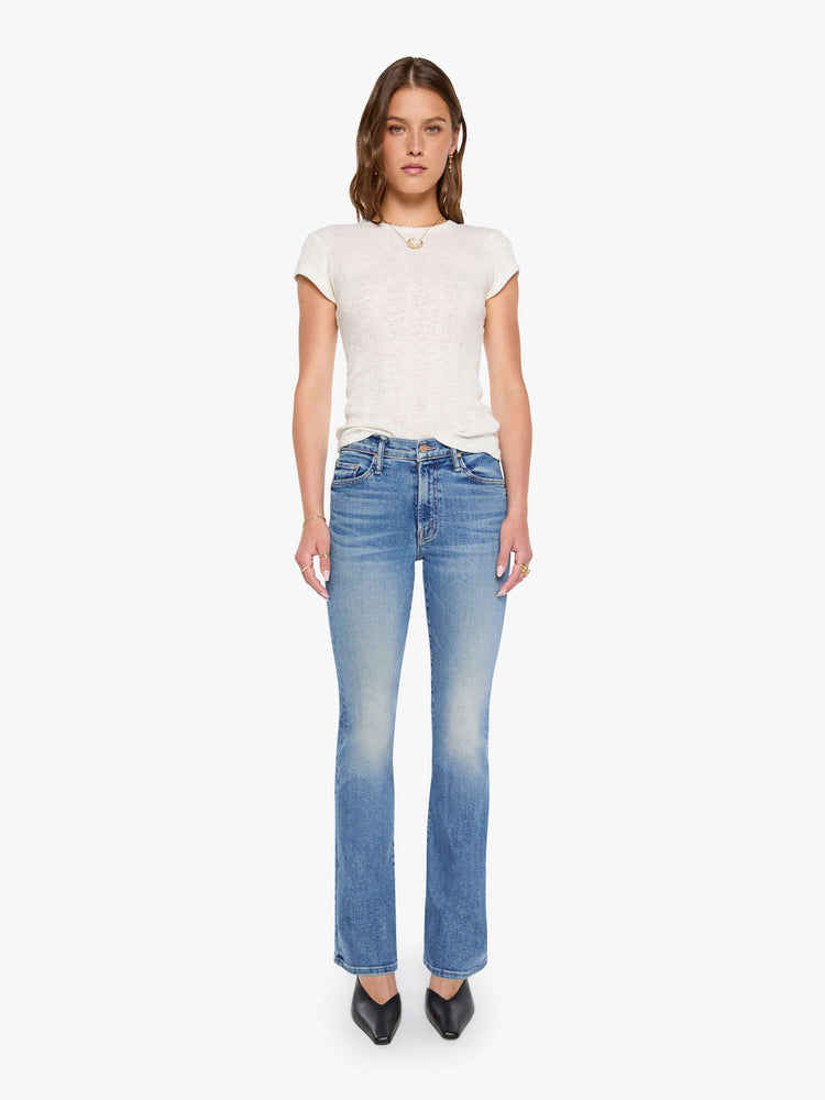 Front view of a woman in mid blue bootcut jeans with a mid rise, zip fly and a long 31-inch inseam with a clean hem.