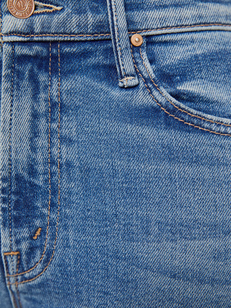 Swatch view of a woman in mid blue bootcut jeans with a mid rise, zip fly and a long 31-inch inseam with a clean hem.