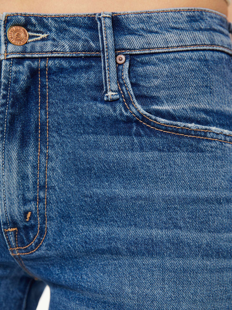 Swatch view of a woman in a med blue mid-rise jeans with a loose fit, wide leg, zip fly and a 28.25-inch inseam with a clean hem.