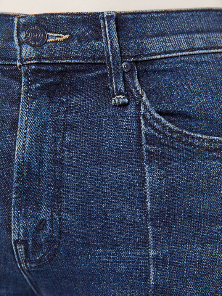 Swatch view of a woman in a dark blue high-waisted bootcut features a zip fly, seamed details down the front, a 31-inch inseam and a frayed triple step-hem.