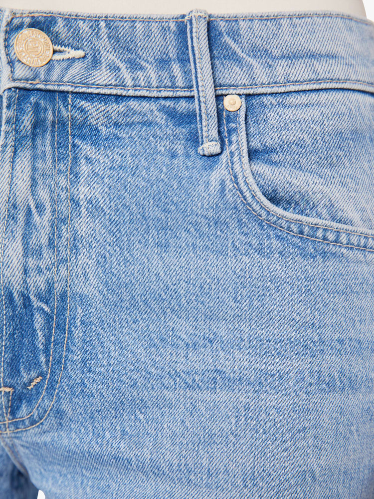 Swatch view of a woman in a light blue mid-rise jeans with a loose fit, wide leg and ankle-length inseam with a clean hem.