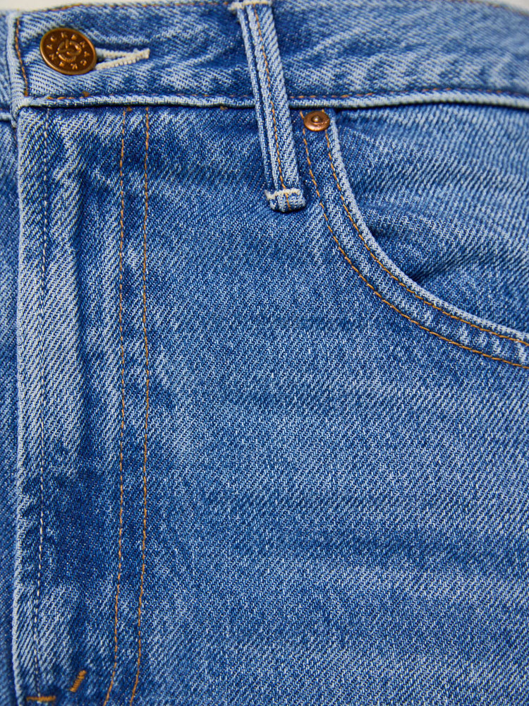 Swatch view of  woman in a mid blue high waisted jean with a wide leg  with a curved outer seam and a long 33.5-inch inseam with a clean hem. 