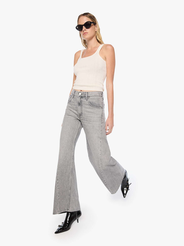 Walking view of a woman in a washed grey high-rise jeans have a zip fly, a loose wide leg with a curved outer seam and a 32-inch inseam with a clean hem.