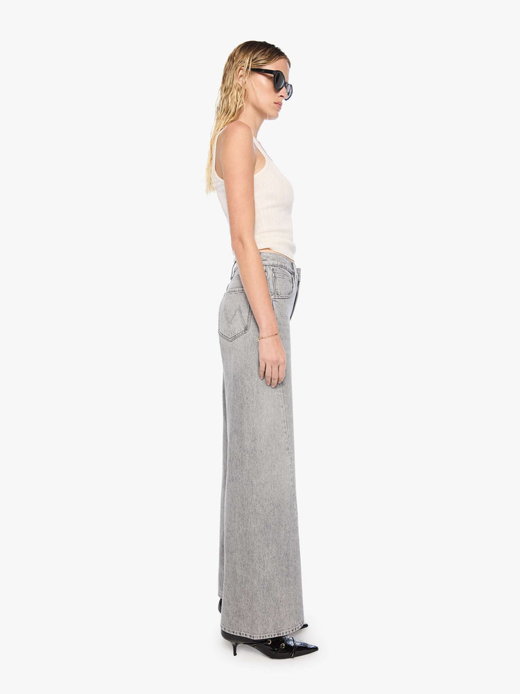 Side view of a woman in a washed grey high-rise jeans have a zip fly, a loose wide leg with a curved outer seam and a 32-inch inseam with a clean hem.