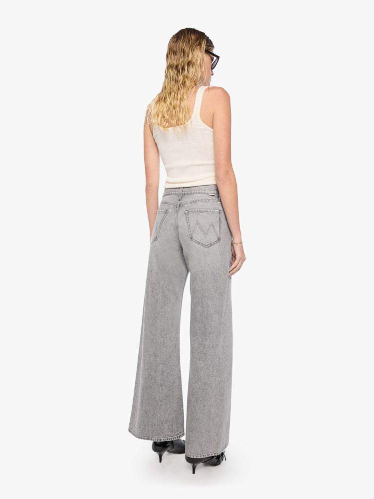 Back view of a woman in a washed grey high-rise jeans have a zip fly, a loose wide leg with a curved outer seam and a 32-inch inseam with a clean hem.