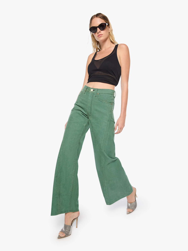 Walking view of a woman in wide leg corduroy designed to sit on the hips with a slouchy fit, these high-rise pants have a zip fly, a loose wide leg with a curved outer seam and a 32-inch inseam with a clean hem.
