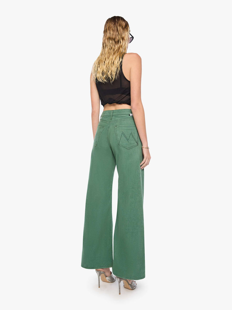 Back view of a woman in wide leg corduroy designed to sit on the hips with a slouchy fit, these high-rise pants have a zip fly, a loose wide leg with a curved outer seam and a 32-inch inseam with a clean hem.
