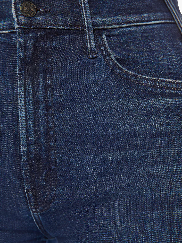 Swatch view of a woman dark blue high-rise flare has an ankle-length inseam and a raw hem.