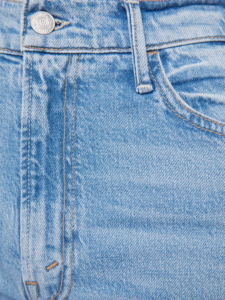 Swatch view of a woman in a light blue high-rise flare jeans have an ankle-length inseam, zip fly and a raw hem.