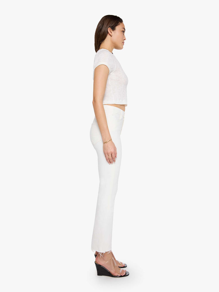 Side view of a womens white wash jean featuring a high rise, flare leg, and a frayed hem.