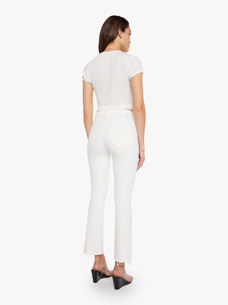 Back view of a womens white wash jean featuring a high rise, flare leg, and a frayed hem.