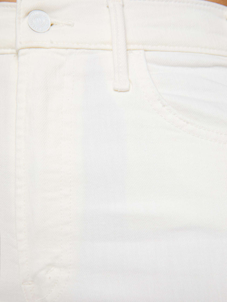 Swatch view of a women wearing a pair of white flare jeans with an ankle length raw cut hem.
