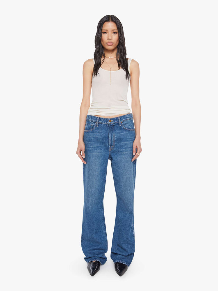 Front view of a woman in mid blue  low-slung jeans with a zip fly, long 33-inch inseam with a loose leg and slouchy fit. 