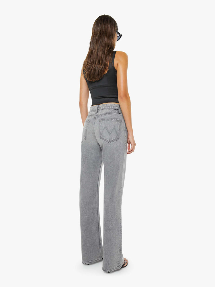 Back view of a woman in a grey low-slung jeans feature a zip fly, long 33-inch inseam with a loose leg and slouchy fit.