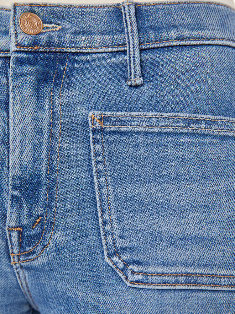 Swatch view of a woman in  a mid rise flare, zip fly, patch pockets, a 31-inch inseam and a clean hem.