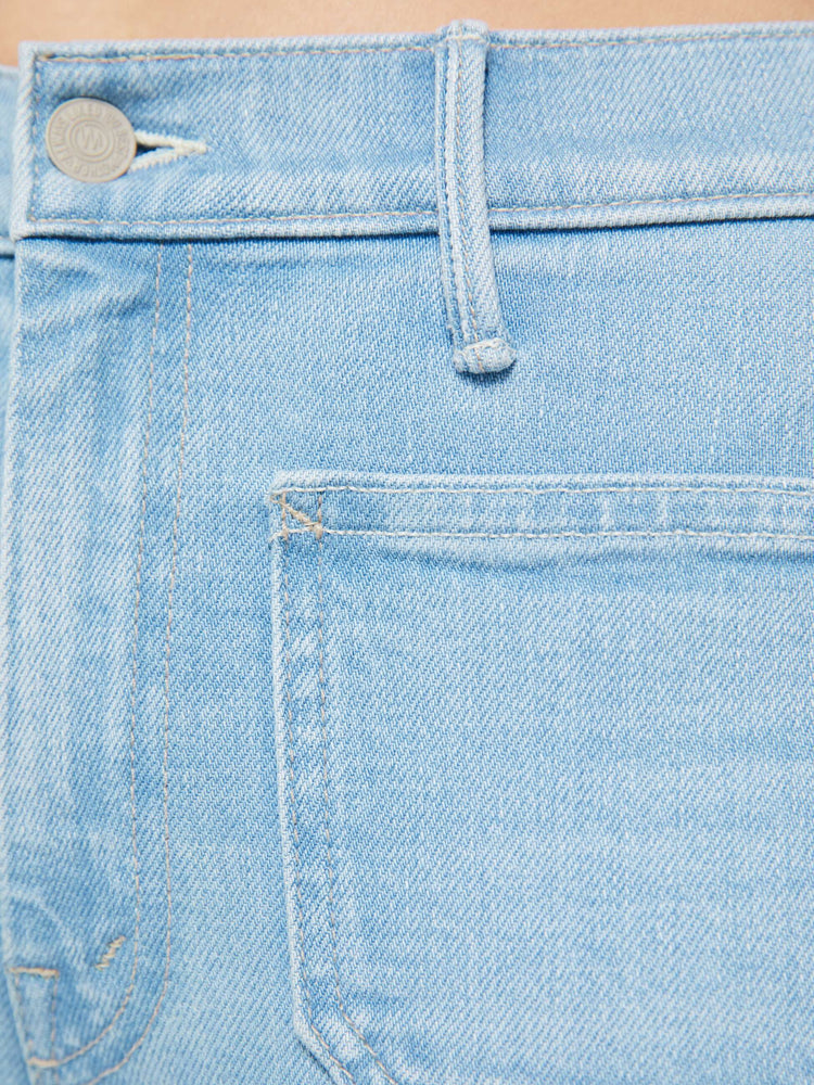 Swatch view of a woman in a light blue  flare has a mid rise, zip fly, patch pockets, a 31-inch inseam and a clean hem. 