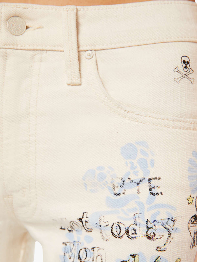 Swatch view of a woman in an off white with hand drawn doodles in light blue and black mid-rise jeans with a wide straight leg, zip fly and clean 30-inch inseam.