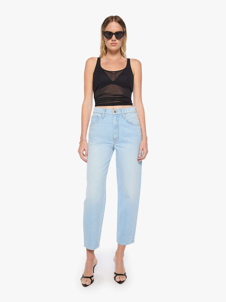 Front view of a woman in light blue denim with a straight super high-waisted pants have a zip fly and an ankle-length inseam.