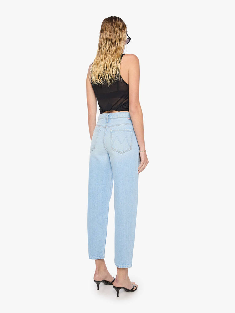 Back view of a woman in light blue denim with a straight super high-waisted pants have a zip fly and an ankle-length inseam.