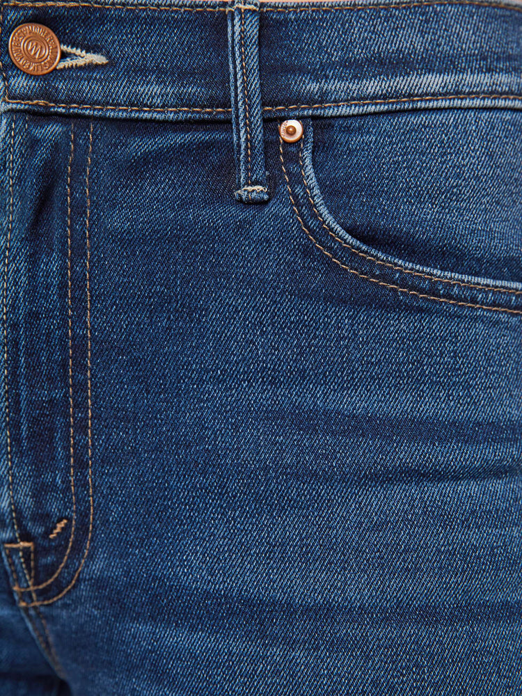 Swatch view of a woman in a dark blue high-waisted bootcut jeans with a zip fly and a 31-inch inseam with a clean hem.