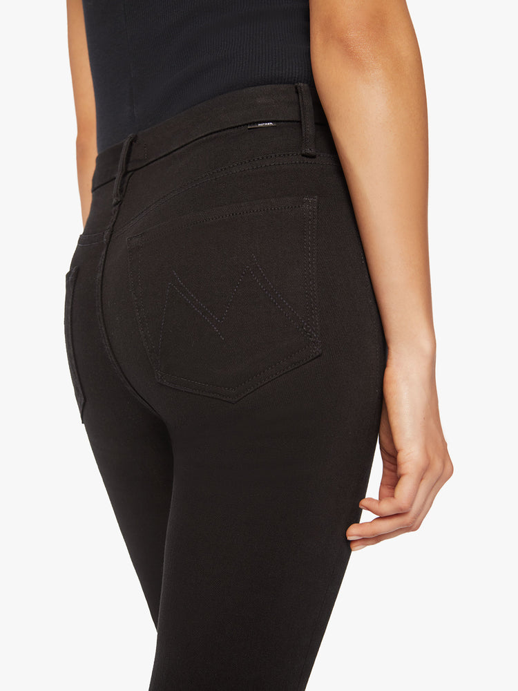 Back close up view of a womens black skinny jean, featuring a high rise and a clean hem.
