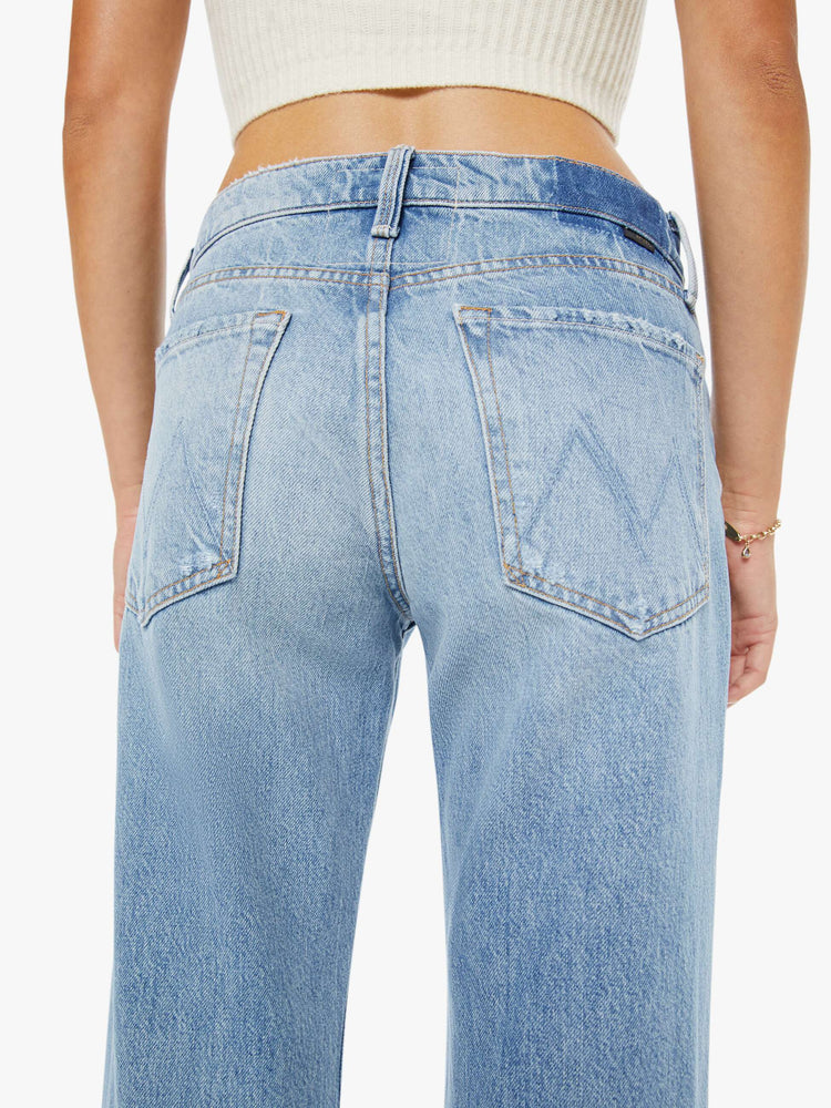 Close up  view of a woman in a light blue  mid-rise bootcut with a zip fly, looser leg and a 30-inch inseam with a clean hem. 