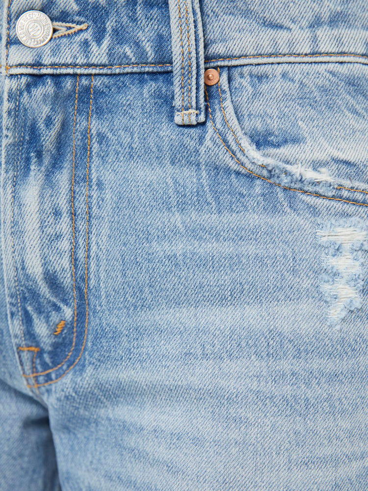 Swatch  view of a woman in a light blue  mid-rise bootcut with a zip fly, looser leg and a 30-inch inseam with a clean hem. 