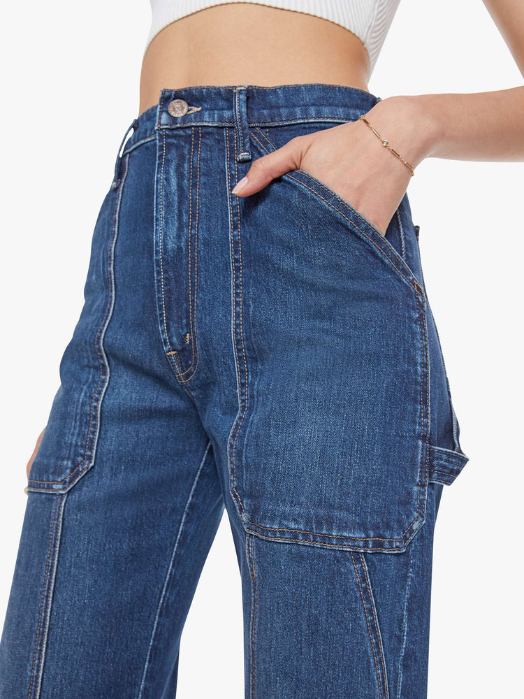 Close up view of a woman in a dark blue wide-leg jeans with a super high rise, oversized front patch pockets, seamed details throughout and a long 32-inch inseam with a clean hem.