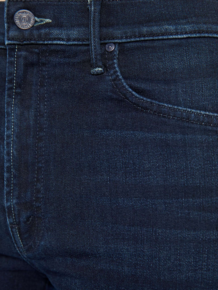 Swatch view of a woman in a dark blue mid-rise jeans with a flared leg, zip fly and a long 31-inch inseam with a clean hem. 