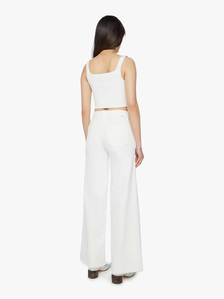 Back view of a woman white wide leg pants with a high rise, long 32-inch inseam and a frayed hem.