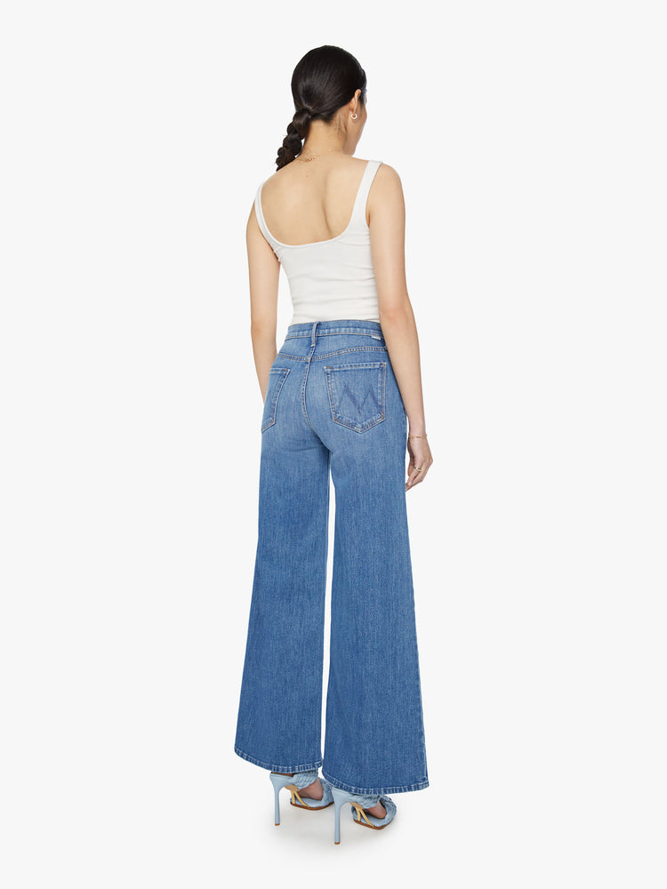 Back view of a woman wide leg pants with a high rise, long 32-inch inseam and a clean hem in a med blue wash.