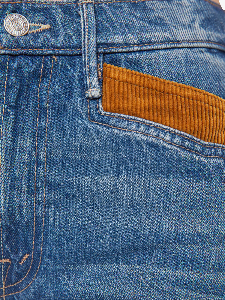 Swatch view of a woman in a mid blue high-rise flare with a zip fly, off-center back pockets, a long 34-inch inseam and a clean hem.