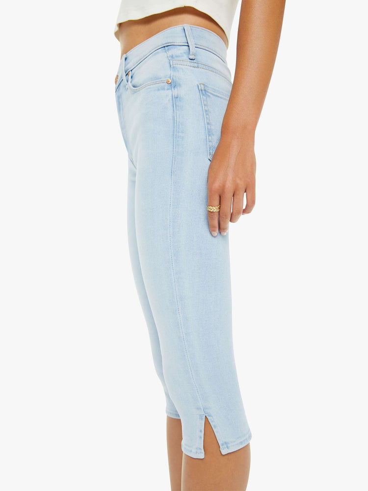Close up view of a woman in a light blue high-waisted pants with a skinny leg, zip fly and a capri-length inseam.