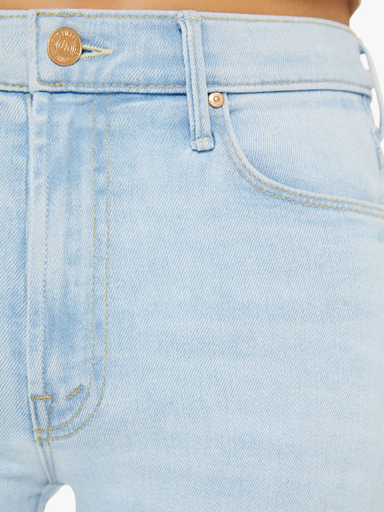 Swatch view of a woman in a light blue high-waisted pants with a skinny leg, zip fly and a capri-length inseam.