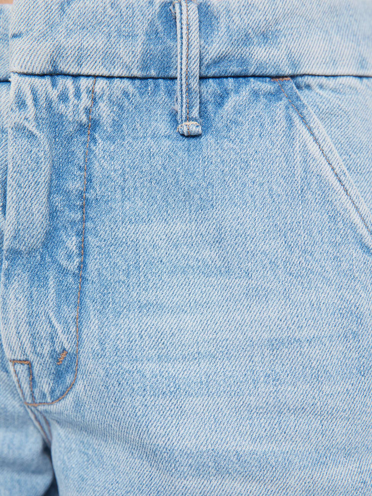Swatch view of a woman in a light blue mid-rise  bootcut with a zip fly, slit pockets, looser leg and a long 32-inch inseam with a clean hem. 