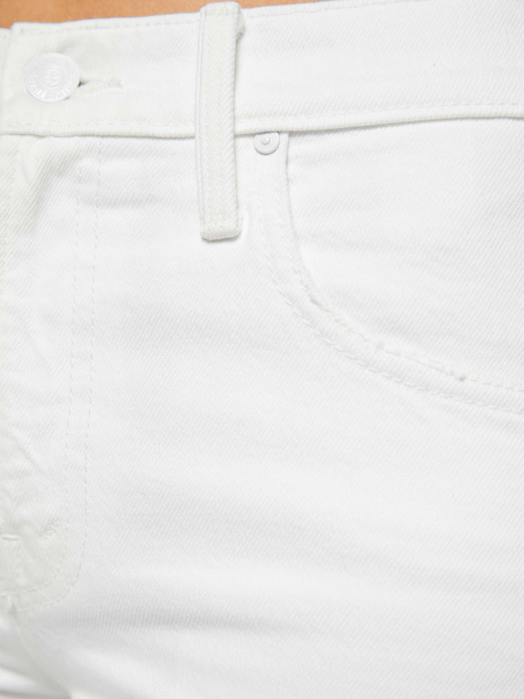 Swatch view of a woman in a white mid-rise bootcut with a zip fly, looser leg and a long 31-inch inseam with a clean hem.