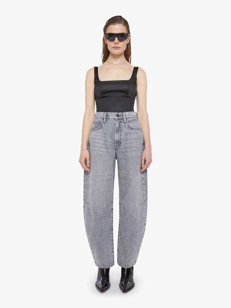 Front view of a woman in a super high-waisted jeans with a zip fly, curved, tapered leg and an ankle-length inseam with a clean hem.