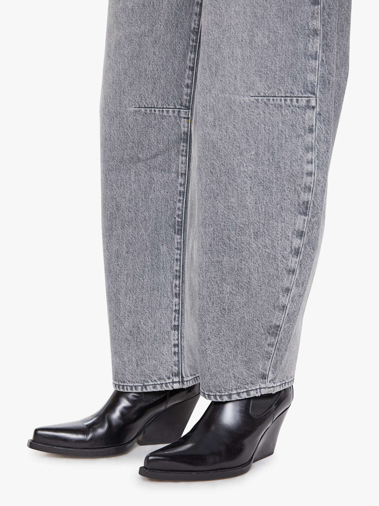 Hem view of a woman in a super high-waisted jeans with a zip fly, curved, tapered leg and an ankle-length inseam with a clean hem.