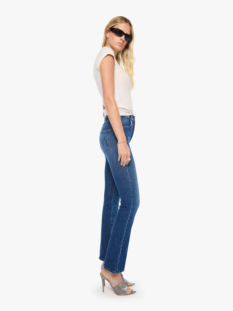 Side view of a woman in high-rise flare with Western-inspired details at the waist, a zip fly, 31-inch inseam and a clean hem.