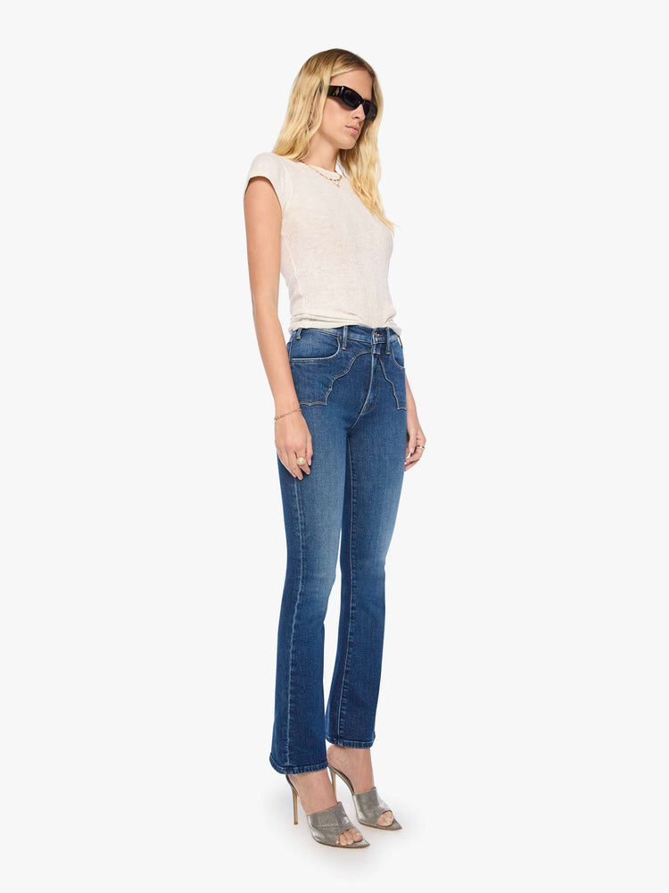 Side angle view of a woman in high-rise flare with Western-inspired details at the waist, a zip fly, 31-inch inseam and a clean hem.