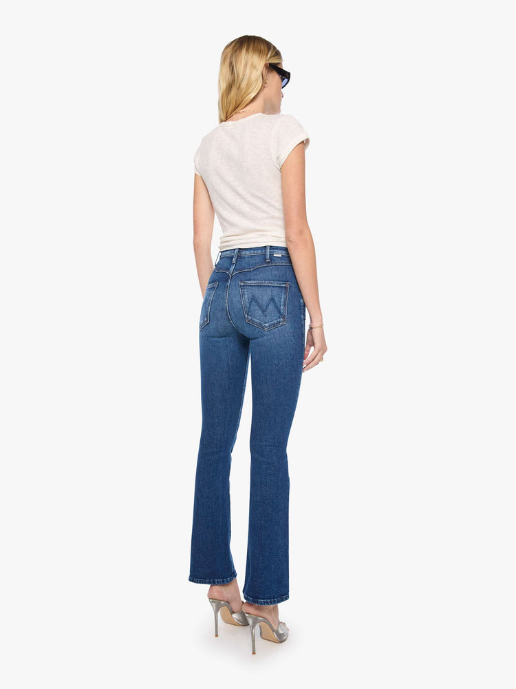 Back view of a woman in high-rise flare with Western-inspired details at the waist, a zip fly, 31-inch inseam and a clean hem.