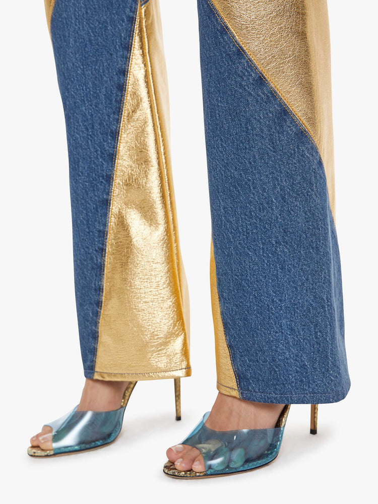 Hem view of a woman in a super high-waisted bootcut jeans with a zip fly and a long 34-inch inseam with a clean hem in a mid blue with gold spiral patches.