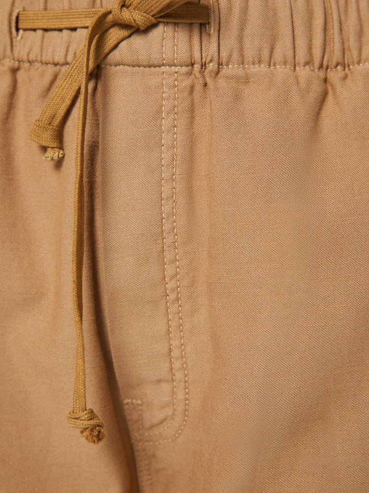 Swatch view of a woman in a super high-waisted khaki pants with a drawstring waistband, wide, curved leg, an ankle-length inseam and a clean hem.