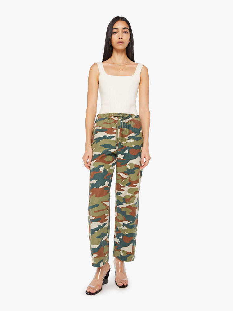 Front view of a woman in a classic camouflage super high-waisted pants with a drawstring waistband, wide, curved leg, an ankle-length inseam and a clean hem. 
