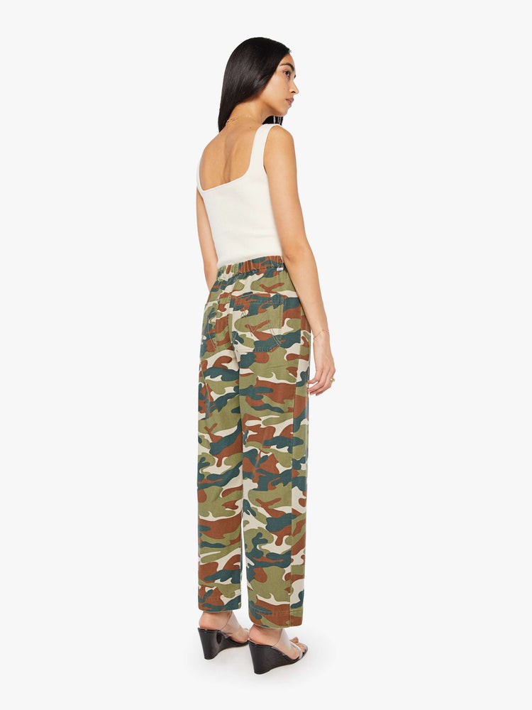 Back view of a woman in a classic camouflage super high-waisted pants with a drawstring waistband, wide, curved leg, an ankle-length inseam and a clean hem. 