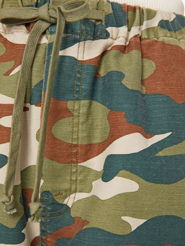Swatch view of a woman in a classic camouflage super high-waisted pants with a drawstring waistband, wide, curved leg, an ankle-length inseam and a clean hem. 
