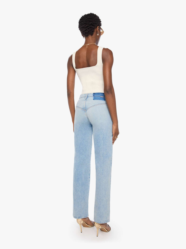 Back view of a woman in a light blue with faux leather and suede patches on the front jean with a high-rise straight-leg with a zip fly, 32-inch inseam and a clean hem
