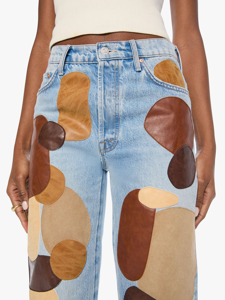 Close up view of a woman in a light blue with faux leather and suede patches on the front jean with a high-rise straight-leg with a zip fly, 32-inch inseam and a clean hem