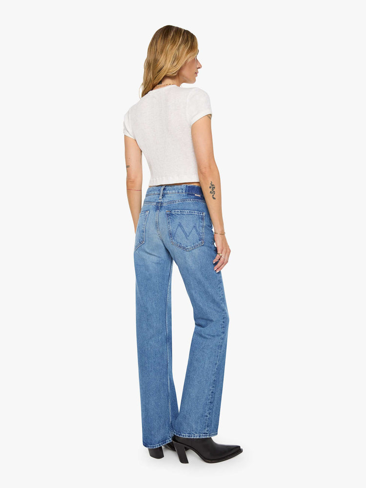 Back view of a woman in a  straight leg with a bit of a kick, the jean features a mid rise, full-length inseam and clean hem in med blue wash.